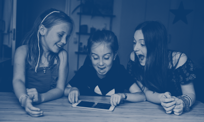 Tre glade piger, der kigger på en iPad