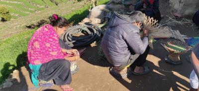 Blind kvinde og mand fletter skamler i Nepals bjerge. 