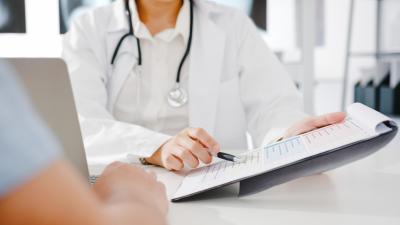 Sundhedstjek: Læge viser formular på clipboard til patient