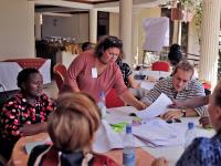 Unge frivillige fra SUMH og partnere fra Uganda arbejder ved et bord