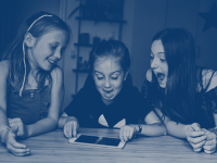 Tre glade piger, der kigger på en iPad