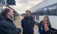 Thorkild Olesen og transportminister Benny Engelbrecht står på en togperron og smiler