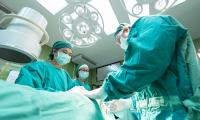 Tre læger står om en patient på en operationsstue